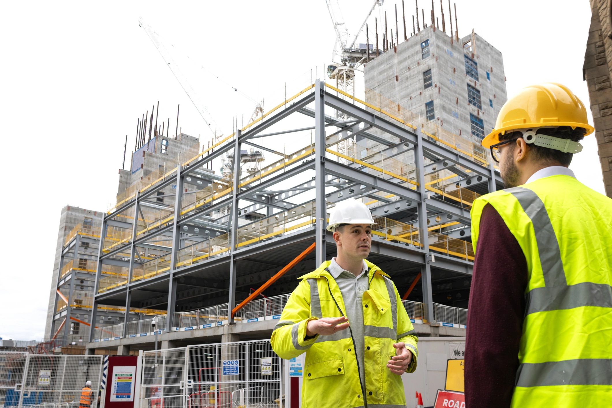 Two engineers reviewing plans at an active construction site